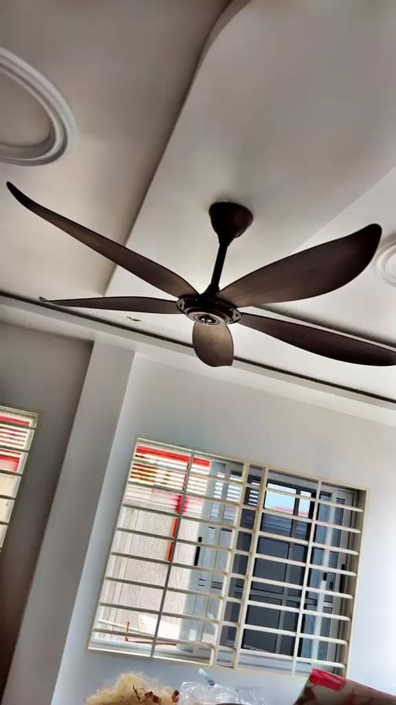 Installed five-blade ceiling fan running in a finished room