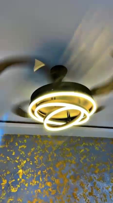 Ceiling fan with an integrated LED ring light running in a decorated room